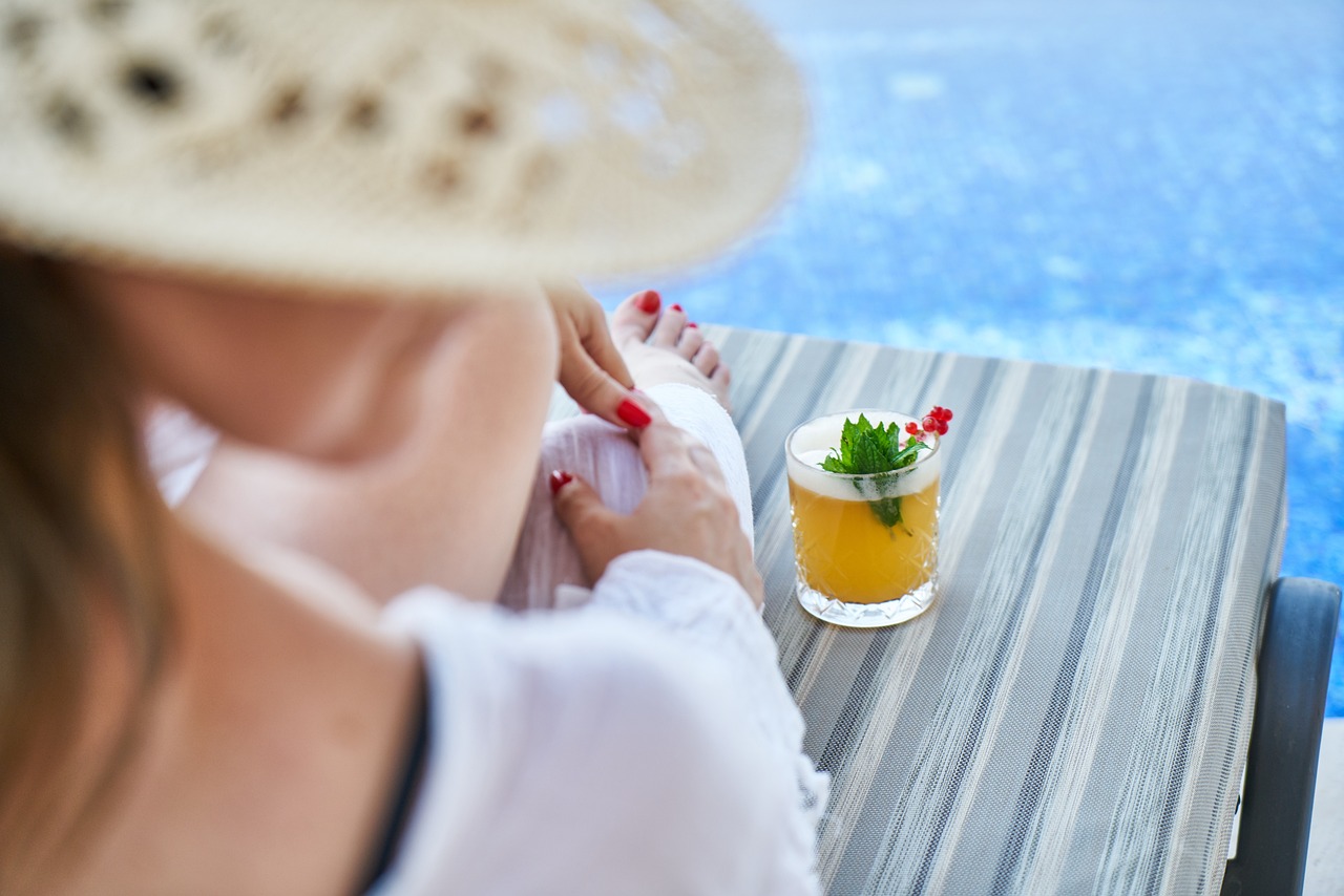 personalized experiences: woman with a cocktail by the pool.